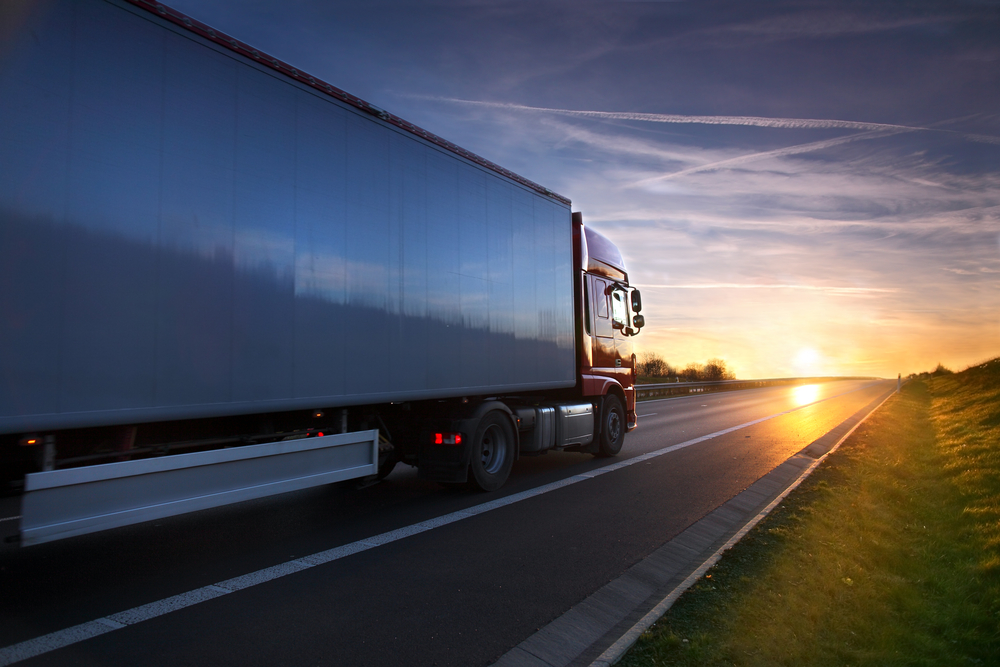 Truck driving into sunset